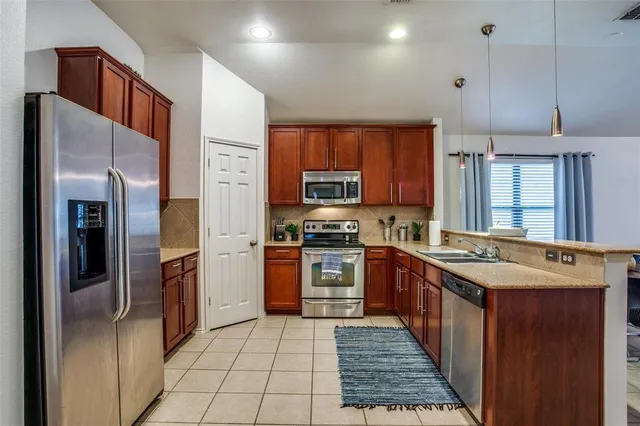 a kitchen with stainless steel appliances granite countertop a refrigerator and a stove top oven