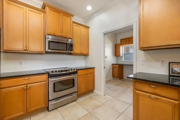 a view of a hallway with wooden floor and a chandelier