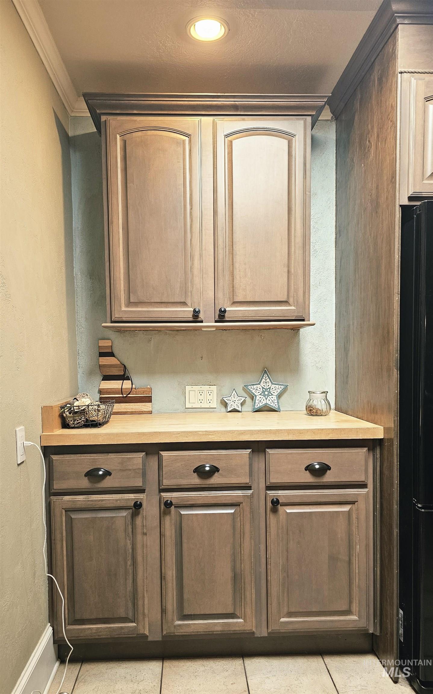712 3rd Street Lewiston, ID 83501 - Photo 5 of 30 Bar area with light countertops, ornamental molding, recessed lighting, light tile patterned floors, and freestanding refrigerator