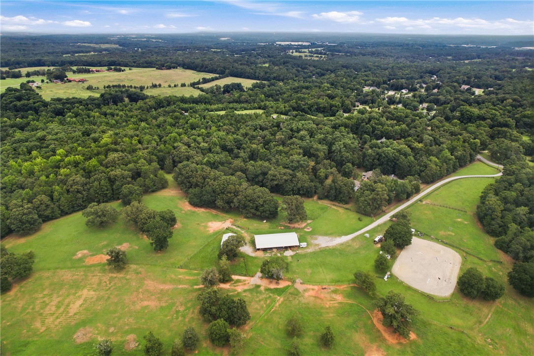 0 Southern Acres Road Anderson, SC 29625 - Photo 24 of 27 Sprawling acreage features lush green pastures, a sizable barn, and a horse riding ring, surrounded by a verdant forest.
