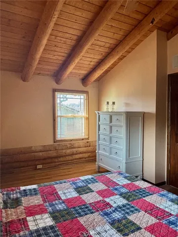 a view of a bedroom with a bed and wooden floor