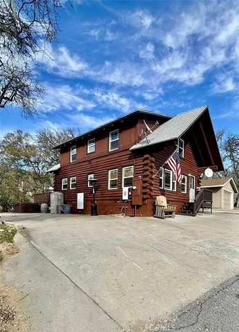 a view of a house with a big yard and large trees