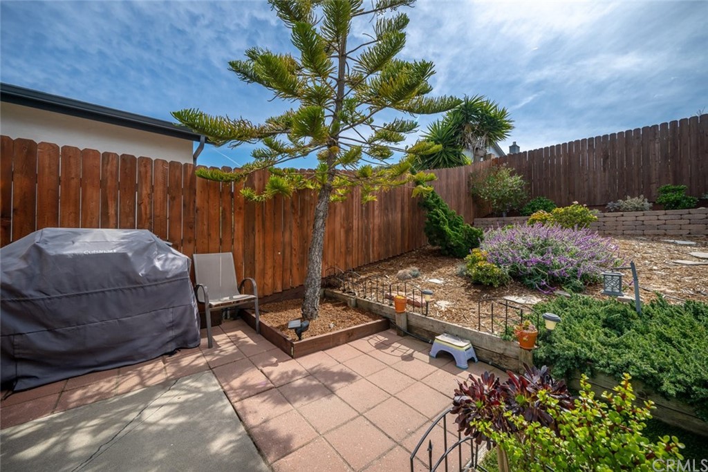 765 Lilac Drive Los Osos, CA 93402 - Photo 39 of 54 a backyard of a house with a table and chairs with wooden fence