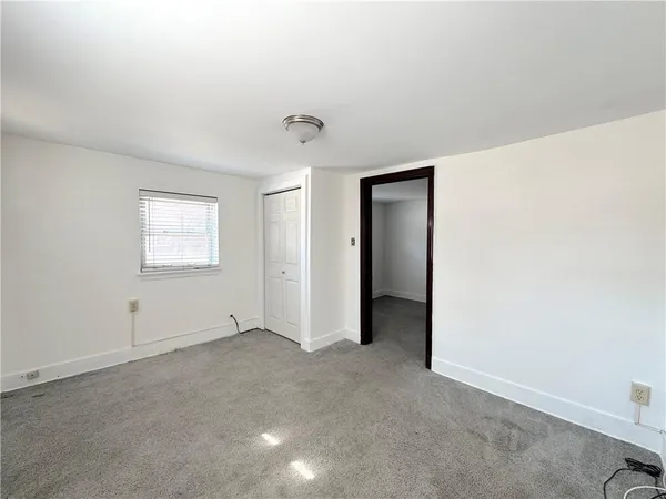 an empty room with windows and closet