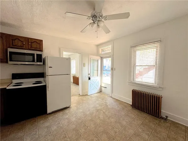 a view of a kitchen with furniture refrigerator and a ceiling fan