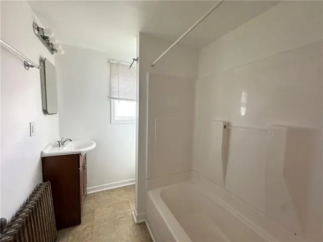 a bathroom with a bathtub sink vanity and mirror