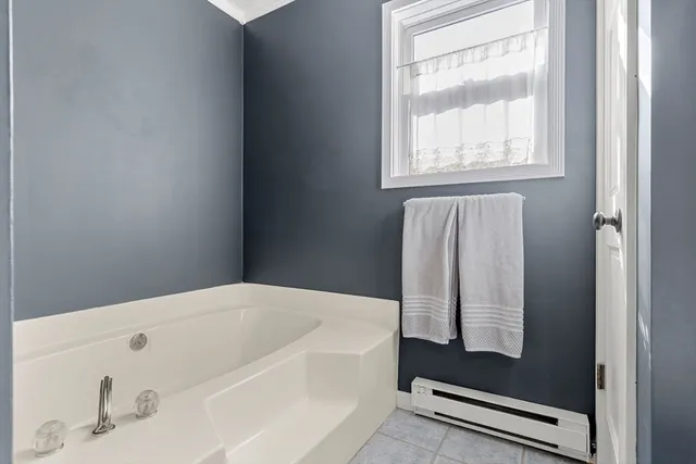 a bathroom with bathtub and window