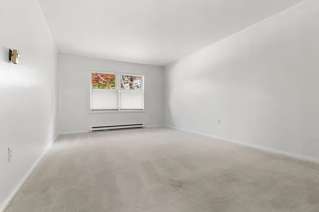 an empty room with windows and cabinet
