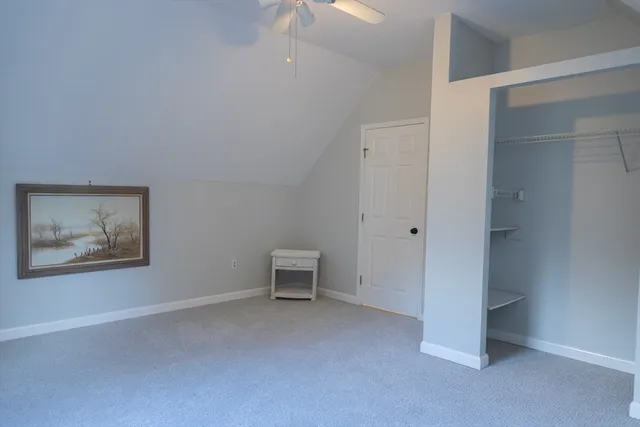an empty room with a door and a fan