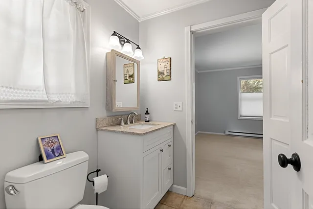 a bathroom with a granite countertop toilet sink and mirror