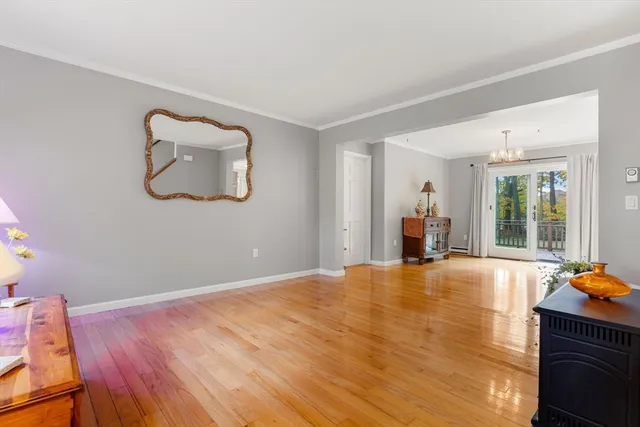 a view of an empty room with window and wooden floor