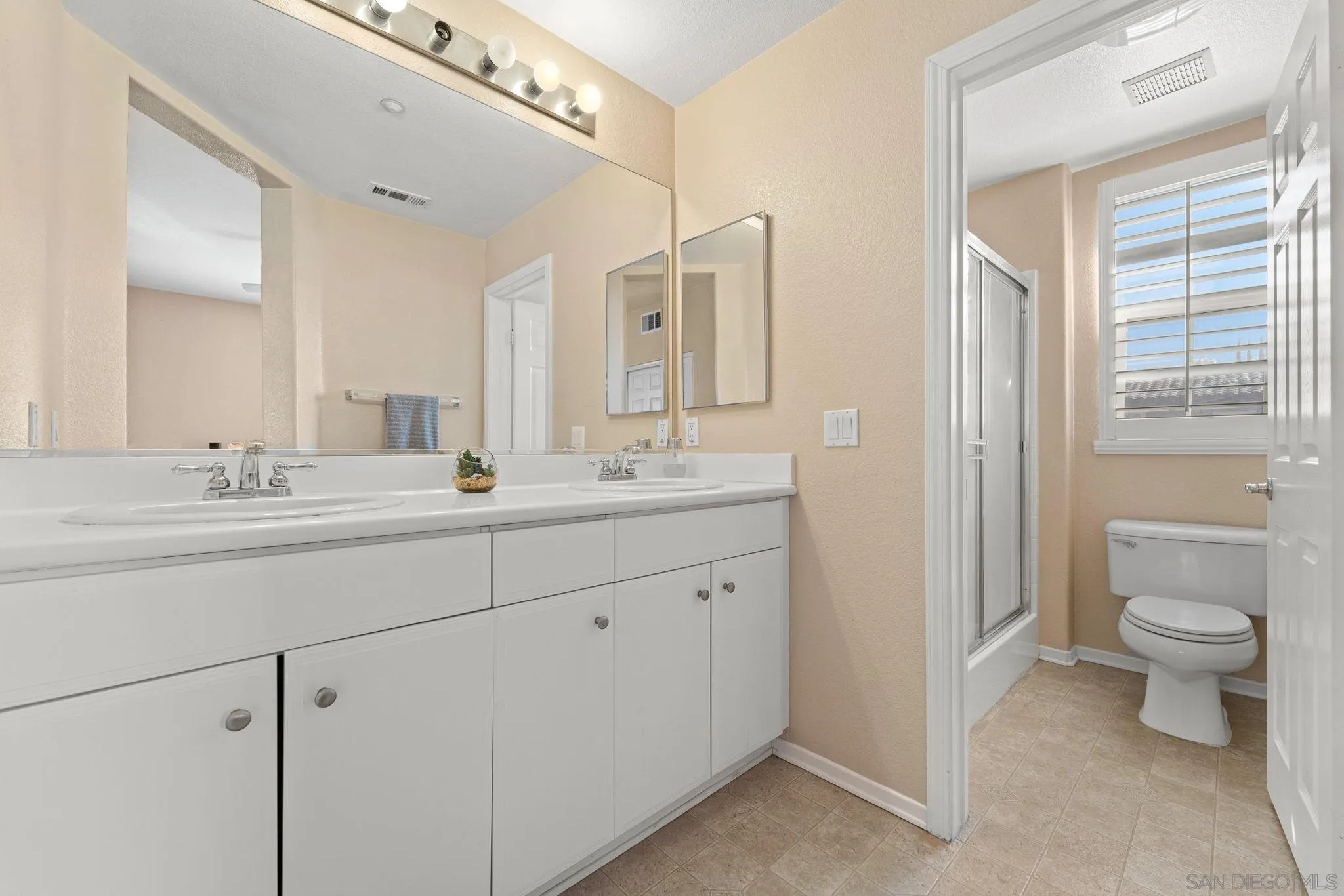 812 Compass Way San Diego, CA 92154 - Photo 21 of 39 a bathroom with a double vanity sink toilet and shower