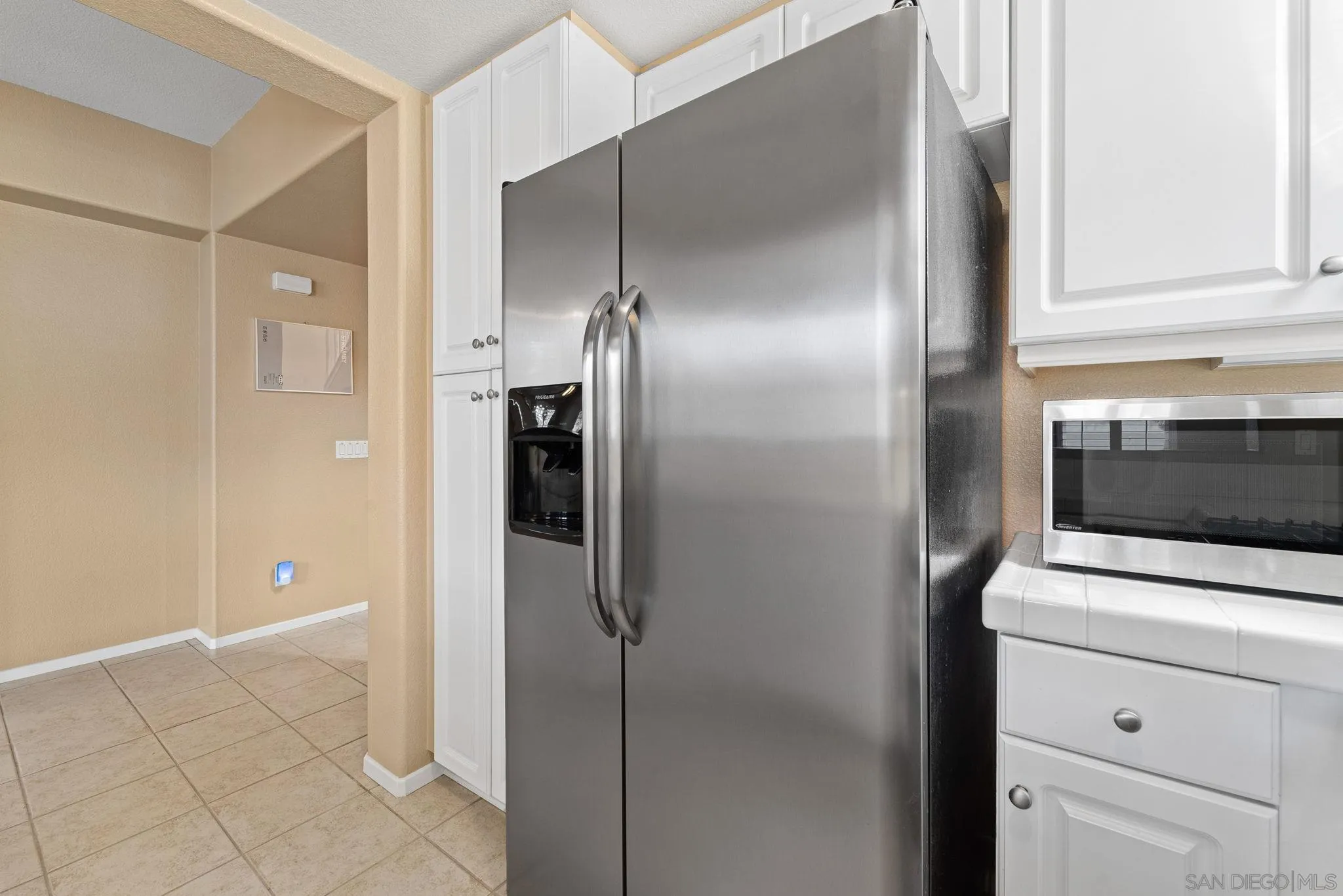 812 Compass Way San Diego, CA 92154 - Photo 8 of 39 a kitchen with a refrigerator and cabinets