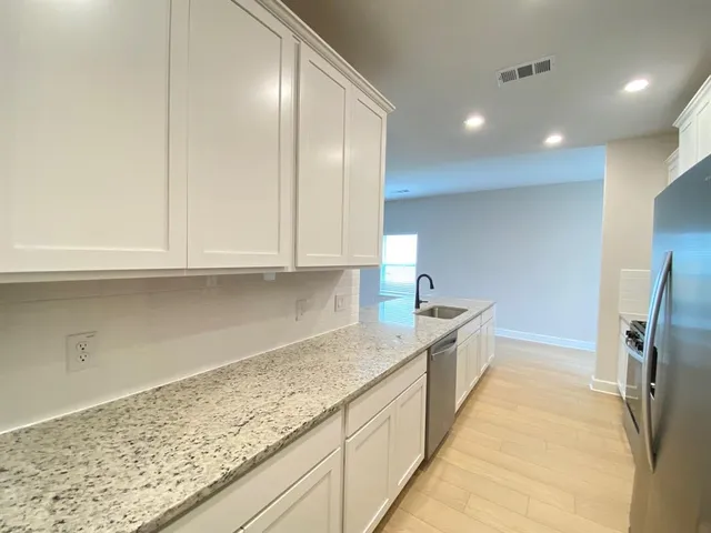 a kitchen with granite countertop sink and cabinets