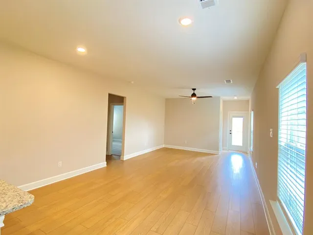 a view of a big room with wooden floor and windows