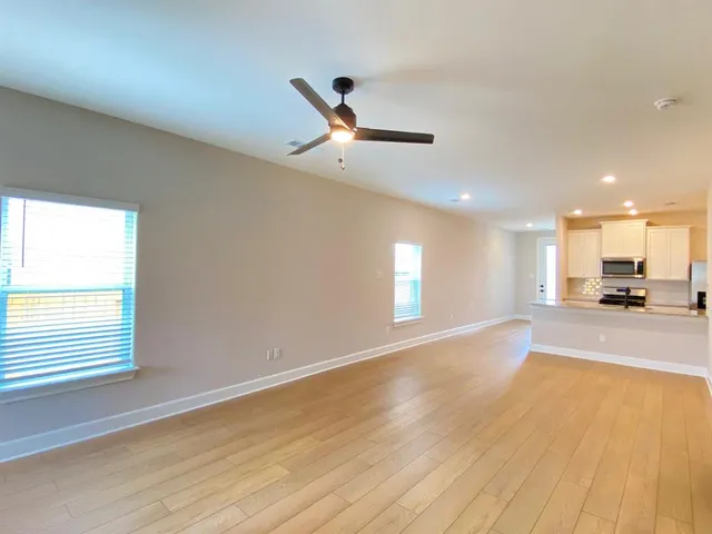 a view of a livingroom with a piano and wooden floor