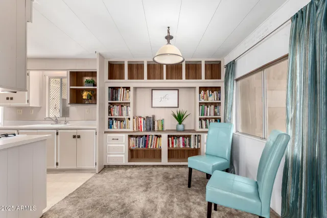 a living room with furniture a bookshelf and a large window