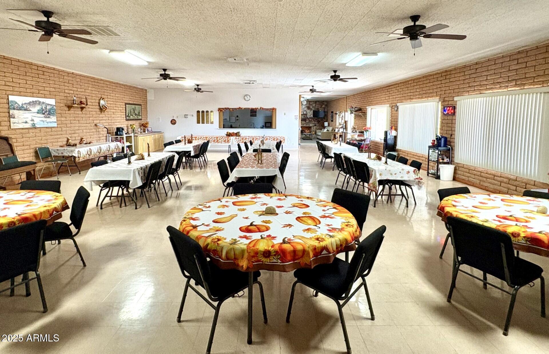 2700 East Allred Avenue, Unit R89 Mesa, AZ 85204 - Photo 25 of 28 a dining room with lots of chairs and a chandelier