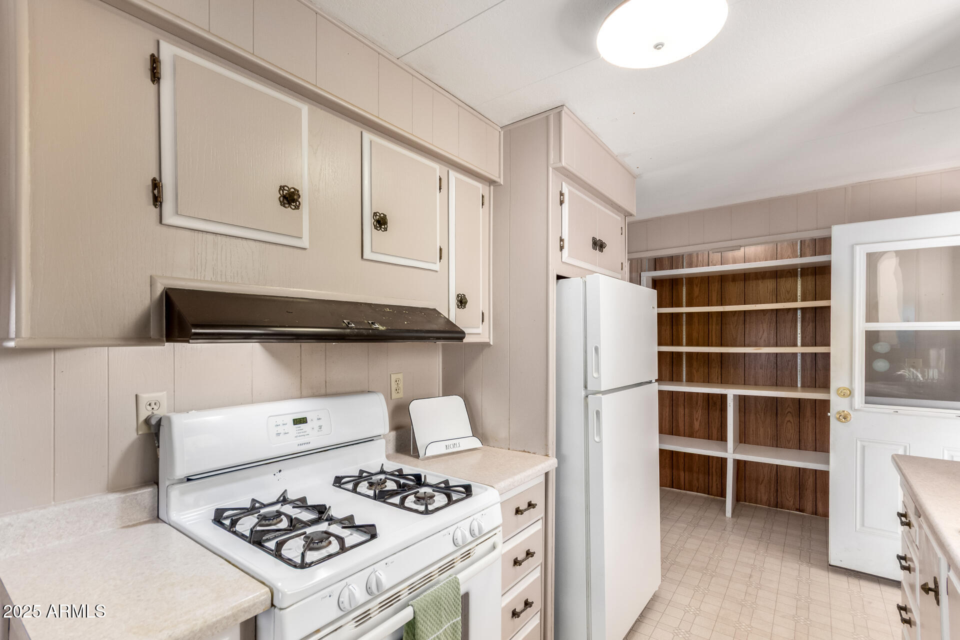 2700 East Allred Avenue, Unit R89 Mesa, AZ 85204 - Photo 9 of 28 a kitchen with a stove and a refrigerator