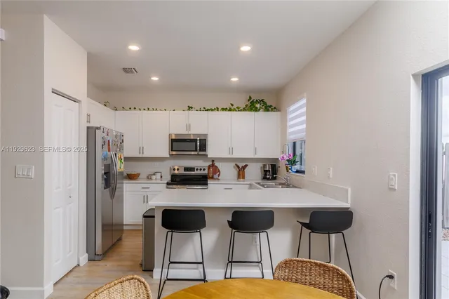 a kitchen with stainless steel appliances kitchen island granite countertop a refrigerator and microwave