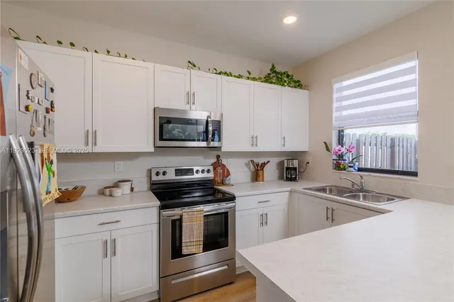 a kitchen with granite countertop a sink stainless steel appliances and cabinets