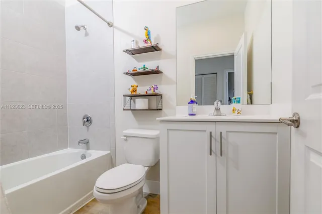a bathroom with a sink toilet vanity tub and shower