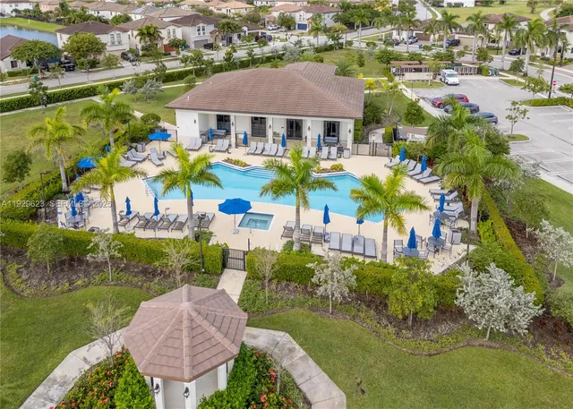 an aerial view of residential houses with outdoor space and swimming pool