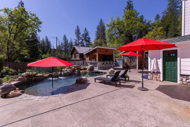 a view of a patio with chairs and tables under an umbrella