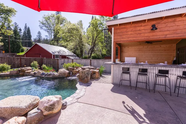 a view of a patio with table and chairs under an umbrella