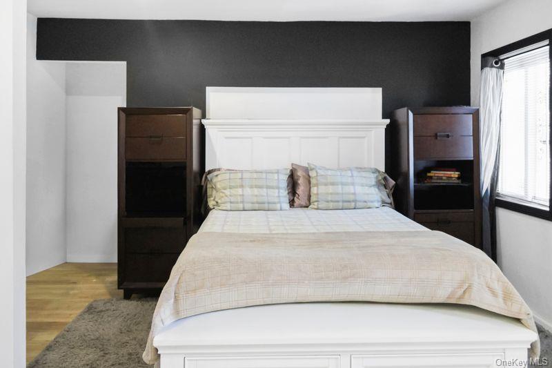 219-19 143rd Road Queens, NY 11413 - Photo 2 of 10 a bedroom with a bed and wooden floor