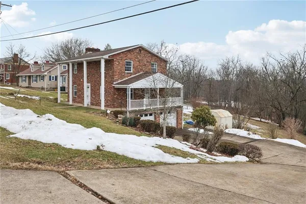 a front view of a house with a yard and lake view