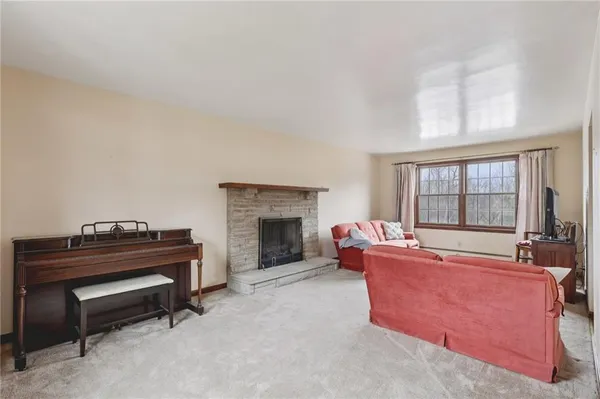 a living room with furniture a fireplace and a large window