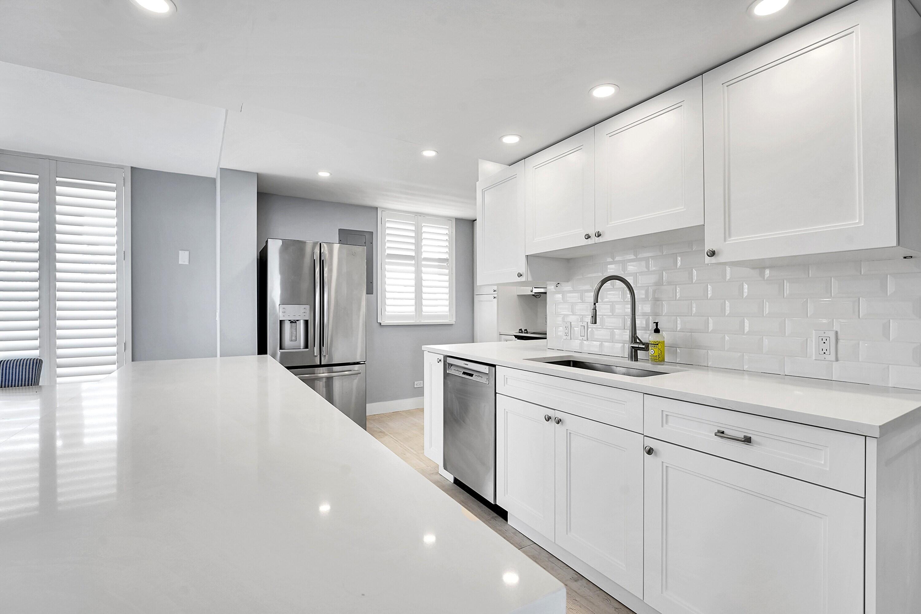 134 Lakeshore Drive, Unit 316 North Palm Beach, FL 33408 - Photo 5 of 30 a kitchen with sink a refrigerator and cabinets
