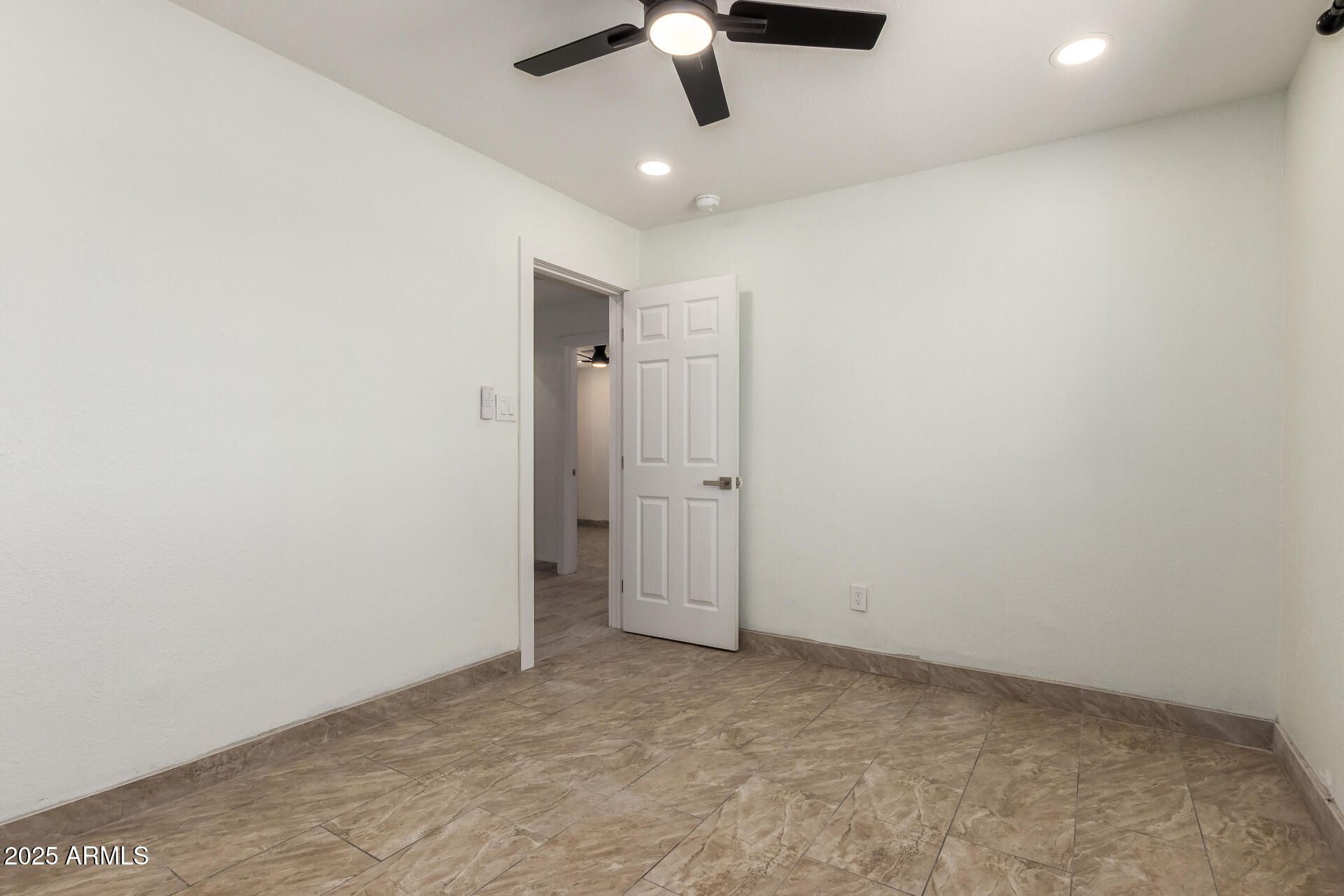 2239 West Bethany Home Road Phoenix, AZ 85015 - Photo 20 of 28 an empty room with a ceiling fan and carpet