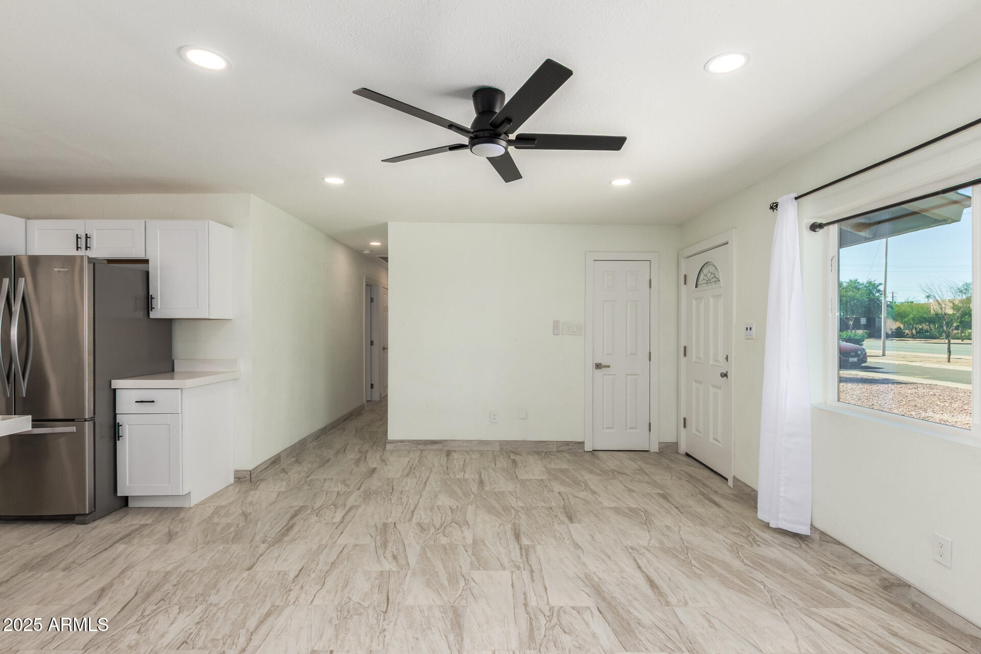 2239 West Bethany Home Road Phoenix, AZ 85015 - Photo 8 of 28 a view of a livingroom with a ceiling fan & a window