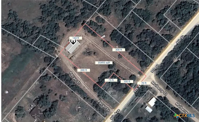 a view of a field with an trees in the background