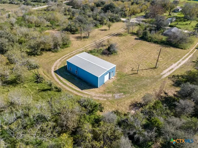 a view of a dry yard with wooden fence