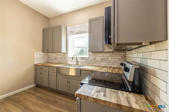 a kitchen that has a sink and a stove in it