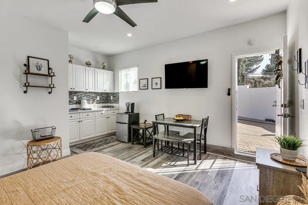 5595 Sweetwater Road Bonita, CA 91902 - Photo 13 of 15 a kitchen with stainless steel appliances kitchen island granite countertop a sink a stove a dining table and chairs with wooden floor
