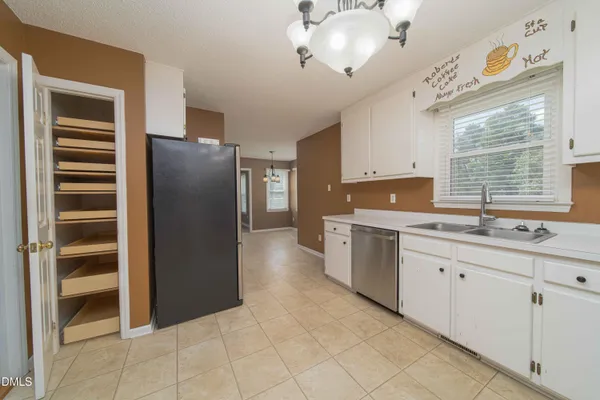 a kitchen with granite countertop a refrigerator and a sink