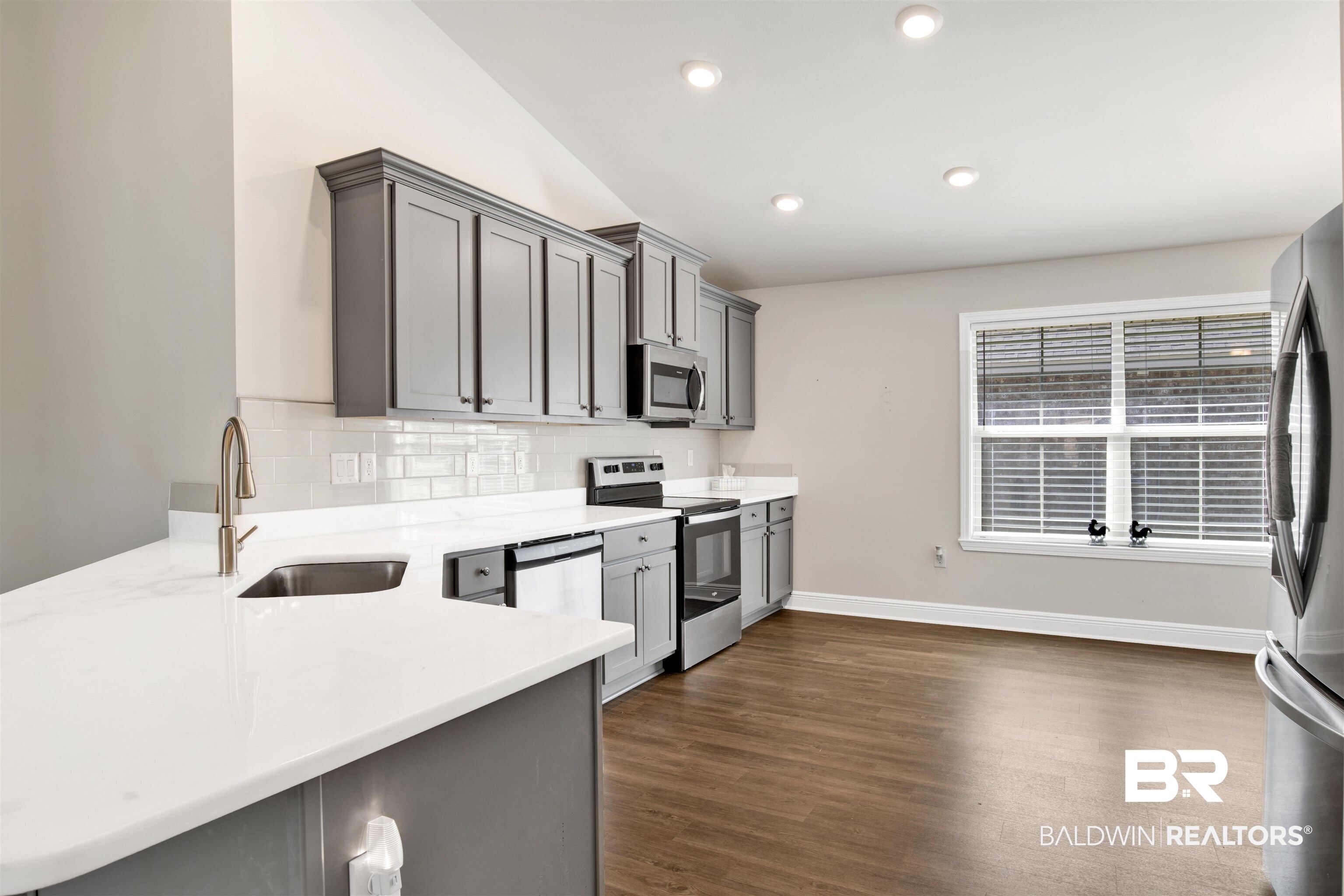 22462 Respite Lane Foley, AL 36535 - Photo 2 of 22 Kitchen featuring sink, dark wood-type flooring, stainless steel appliances, and kitchen peninsula