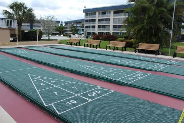 a view of a tennis ground with large trees