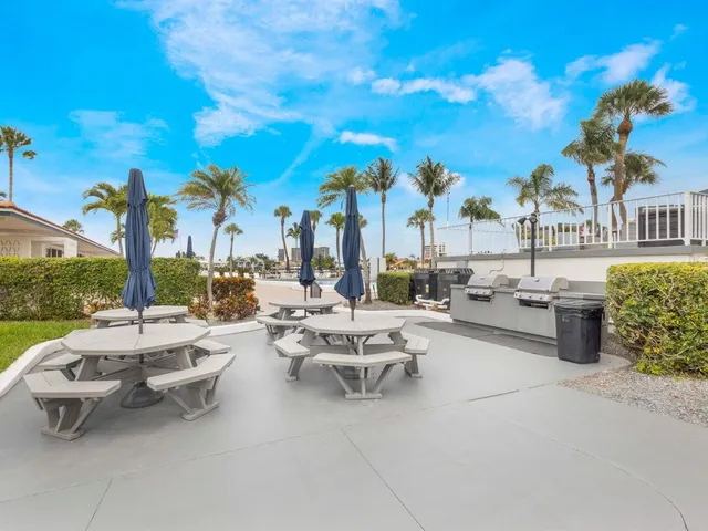 a view of a patio with couches and table and chairs and potted plants