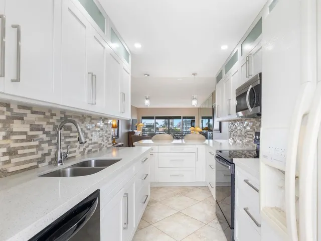 a kitchen with white cabinets and sink