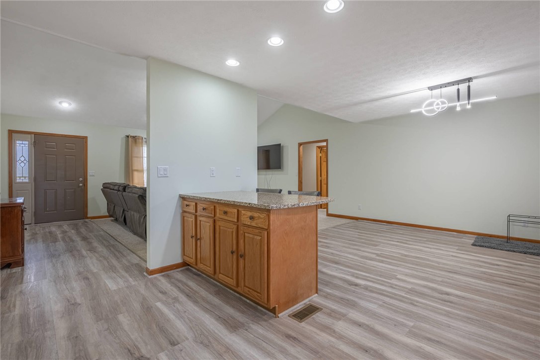 2645 Vance Road St. Paris, OH 43072 - Photo 14 of 35 An inviting open-concept living space features stylish wood plank flooring and contemporary lighting.