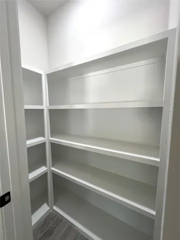 a view of walk in closet with empty racks