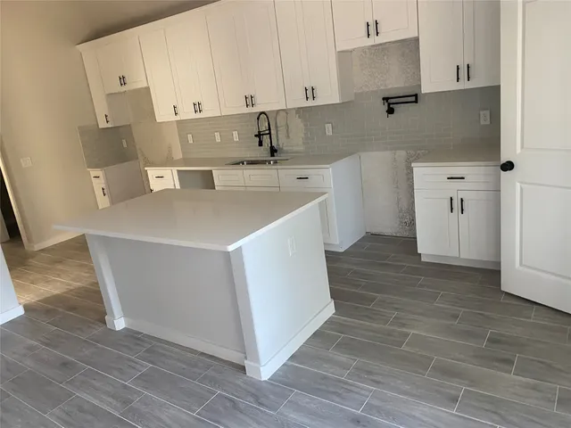 a kitchen with a sink a stove and cabinets