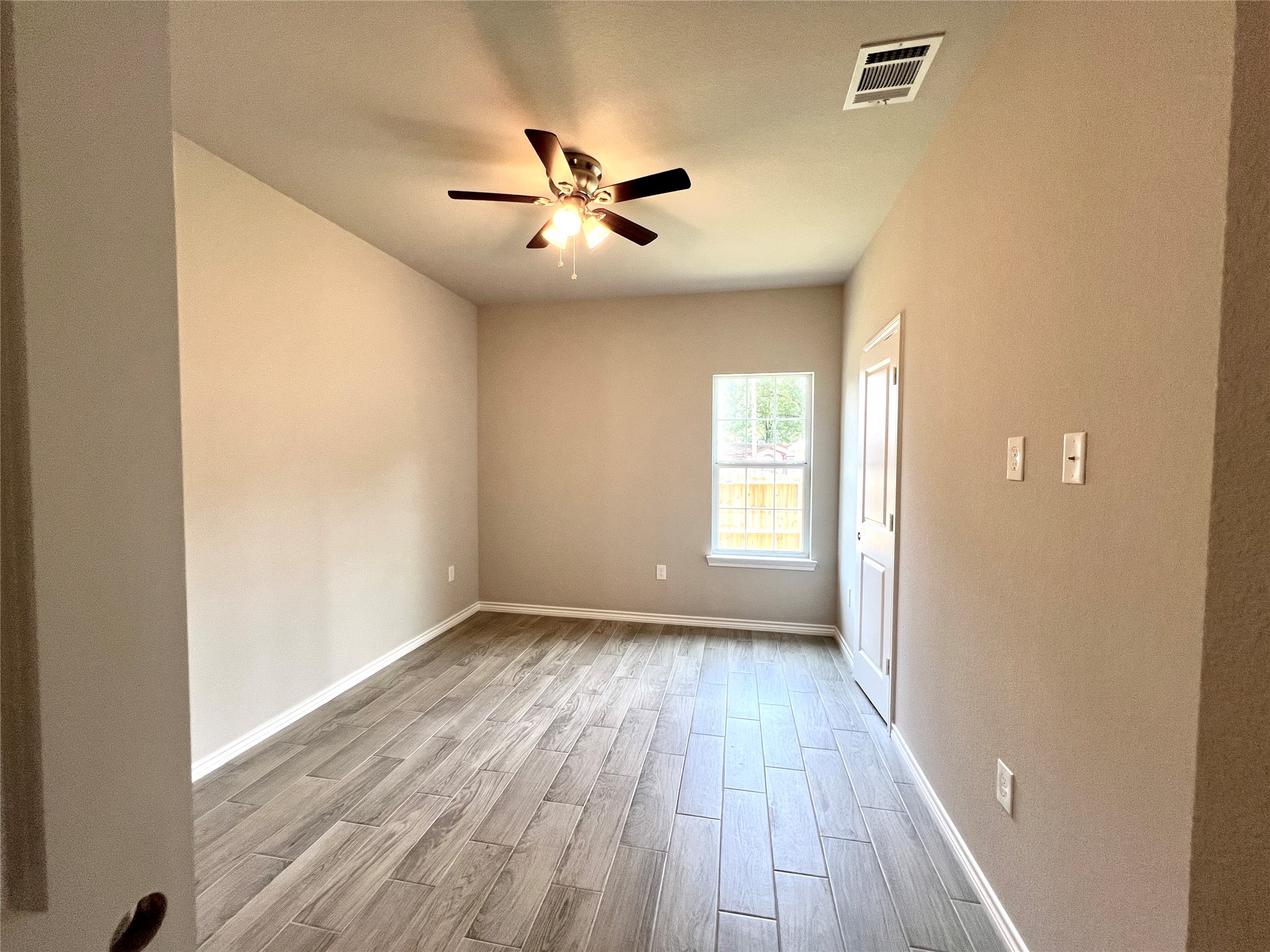16737 East Hammon Montgomery, TX 77316 - Photo 5 of 20 a view of an empty room with wooden floor and a window