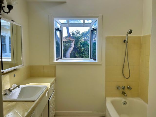 a bathroom with a sink a window and a shower