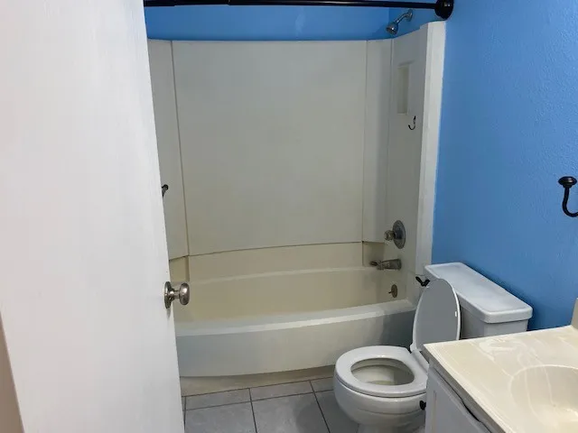 a white toilet sitting next to a bath tub